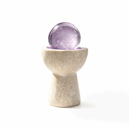 Amethyst crystal sphere chalice arranged in a travertine vessel with natural crystal pieces