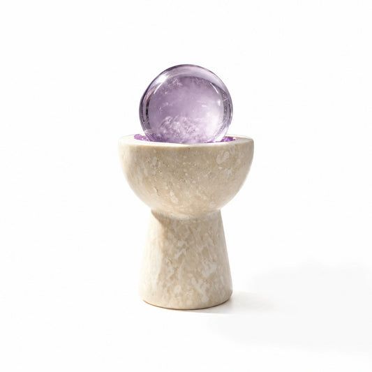 Amethyst crystal sphere chalice arranged in a travertine vessel with natural crystal pieces