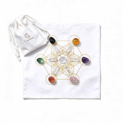 Seven chakra stones and six clear quartz points on a black gold Metatron grid cloth, CrystGrid pouch beside
