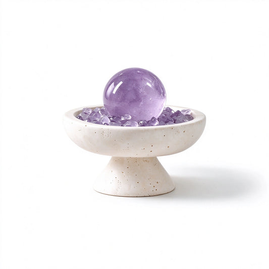 Amethyst crystal sphere arranged in a travertine vessel with natural crystal pieces
