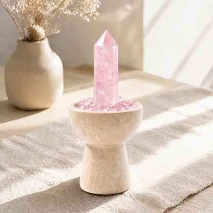 Overhead view of rose quartz crystals and loose crystal stones arranged in the vessel